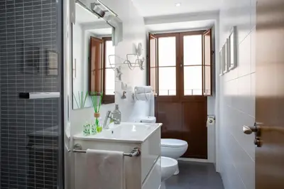 a bathroom with a sink and a toilet and a mirror at SingularStays Valencia Center in Valencia