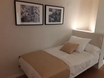 a bed in a room with two pictures on the wall at SLEEP TURIA LLIRIA in Lliria