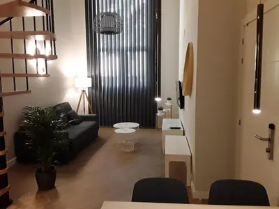 a living room with a black couch and a table at SLEEP TURIA LLIRIA in Lliria