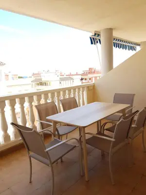 a table and chairs in a room with a balcony at Moncofa Beach in Moncófar