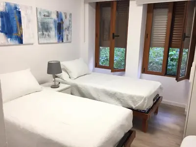two beds in a room with two windows at Garden Turia Downtown in Valencia