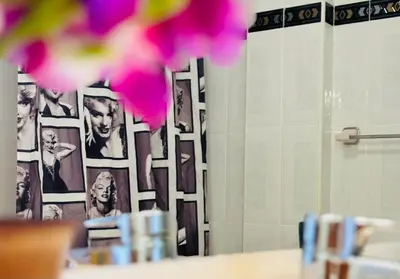 a bathroom with a large mirror with photographs on the wall at Valencia Sol y Playa in Sagunto