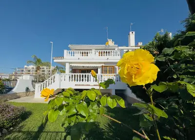 a white house with a yellow flower in front of it at Valencia Sol y Playa in Sagunto