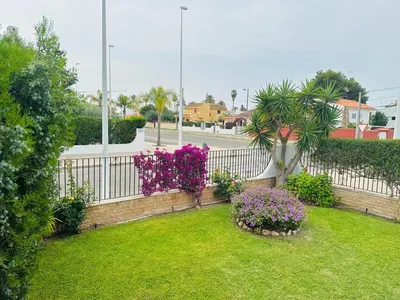 a garden with purple flowers and a white fence at Valencia Sol y Playa in Sagunto