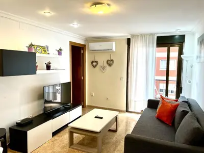a living room with a couch and a tv at Moderno y acogedor apartamento para 6 personas in Valencia