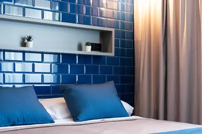 a bedroom with a blue brick wall and a bed at Nest Style Valencia in Valencia
