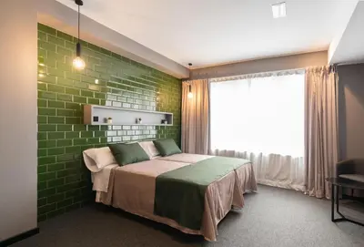 a bedroom with a bed with a green brick wall at Nest Style Valencia in Valencia