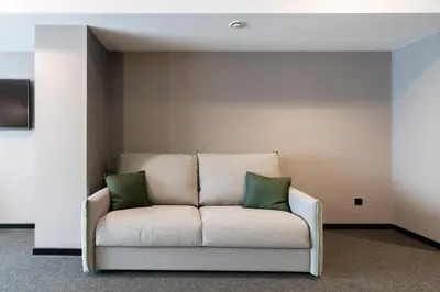 a couch with two green pillows sitting in a room at Nest Style Valencia in Valencia