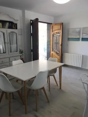 a dining room with a white table and chairs at Casa Ferrada in Burriana