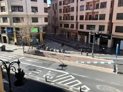 an empty city street with people walking on the sidewalk at Art&Flats Hostel in Valencia