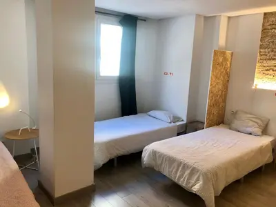 a small room with two beds and a window at Art&Flats Hostel in Valencia