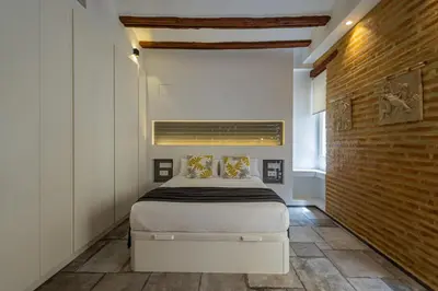 a bedroom with a bed and a brick wall at FLORIT FLATS - CENTER MODERN 1BR 2Bth TERRACE WI-FI AC in Valencia