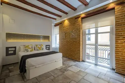 a bedroom with a bed and a brick wall at FLORIT FLATS - CENTER MODERN 1BR 2Bth TERRACE WI-FI AC in Valencia