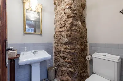 a bathroom with a stone wall next to a sink at Alquería Calatrava B&B in Burriana