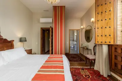 a bedroom with a large bed and a bathroom at Alquería Calatrava B&B in Burriana