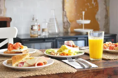 a table with plates of food and a glass of orange juice at Lindala in Valencia