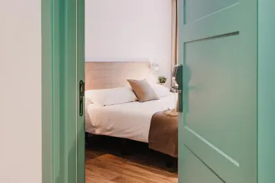 a bedroom with a bed with white sheets and a window at Lindala in Valencia
