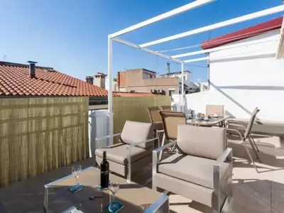 a patio with chairs and a table on a roof at FLORIT FLATS - CENTER 2BR 2BA ATTIC TERRACE VIEW WIFi AC in Valencia