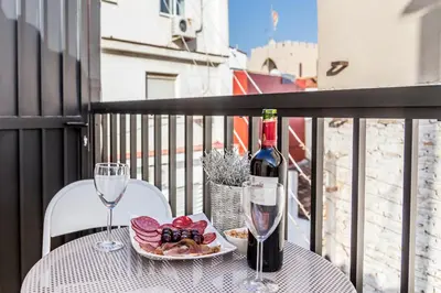 a table with a bottle of wine and a plate of food at FLORIT FLATS - CENTER 2BR 2BA ATTIC TERRACE VIEW WIFi AC in Valencia