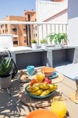a table with a plate of fruit on a balcony at FLORIT FLATS - Cabanyal 3 Bedroom WIFI AC Terrace Beach Penthouse in Valencia