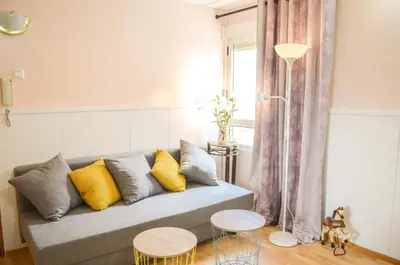 a living room with a couch with yellow and grey pillows at VIRGEN APARTAMENT HOTEL in Cullera