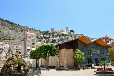 a building with a mountain in the background at VIRGEN APARTAMENT HOTEL in Cullera