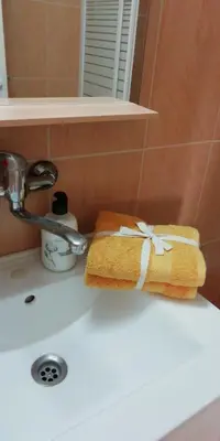a towel sitting on top of a bathroom sink at VIRGEN APARTAMENT HOTEL in Cullera