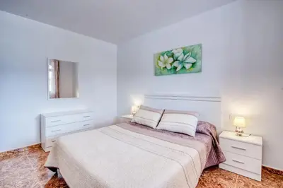 a white bedroom with a bed and two night stands at Family Villa in Benifayó with Year-Round Private Pool in Benifayó