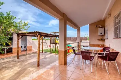 a patio with a table and chairs and a playground at Family Villa in Benifayó with Year-Round Private Pool in Benifayó