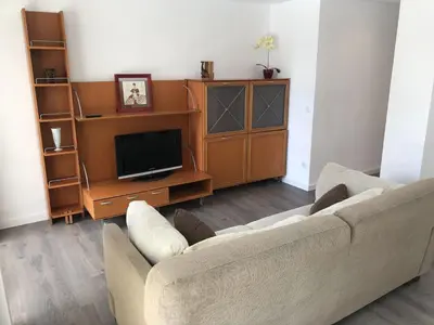 a living room with a couch and a tv at Sun & Beach Pobla in Puebla de Farnals