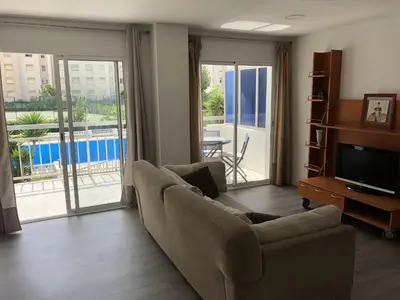 a living room with a couch and a television at Sun & Beach Pobla in Puebla de Farnals