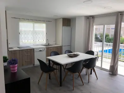 a kitchen with a table and chairs and a kitchen with a window at Sun & Beach Pobla in Puebla de Farnals