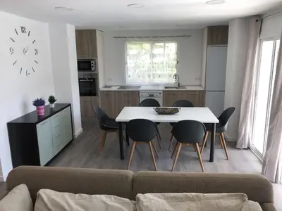 a kitchen and dining room with a table and chairs at Sun & Beach Pobla in Puebla de Farnals