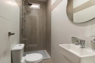 a bathroom with a toilet and a sink and a mirror at Bioparc Metro Valencia in Valencia