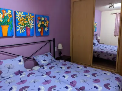 a bedroom with a bed with purple walls and a mirror at Apartamento zona residencial Montesol in La Eliana