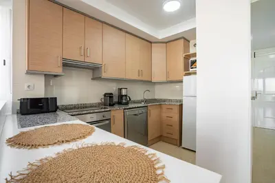 a kitchen with wooden cabinets and a counter top at Ideally Located Holiday Apartment in Moncófar