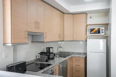 a kitchen with wooden cabinets and a white refrigerator at Ideally Located Holiday Apartment in Moncófar
