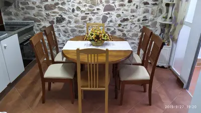 a wooden table with chairs and a vase of flowers on it at Rosita Casa Rural in Estivella