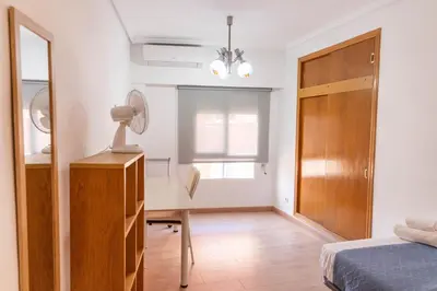 a bedroom with a bed and a desk and a mirror at Vacaciones en Valencia in Burjasot