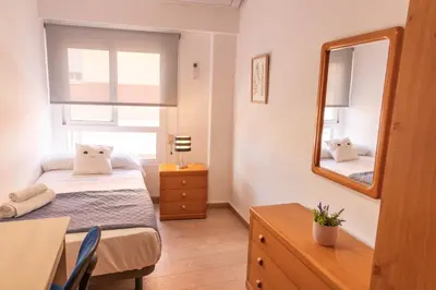 a small bedroom with a bed and a mirror at Vacaciones en Valencia in Burjasot