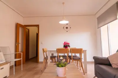 a dining room and living room with a table and chairs at Vacaciones en Valencia in Burjasot