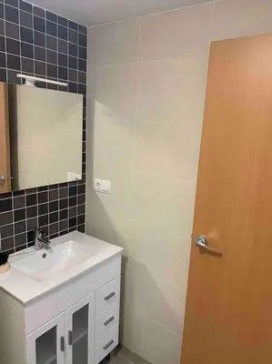 a bathroom with a sink and a mirror and a door at The Apartment Olivia in Moncófar
