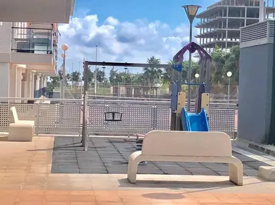a white bench sitting on top of a playground at The Apartment Olivia in Moncófar