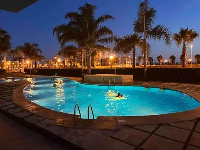 a large pool with people swimming in it at night at The Apartment Olivia in Moncófar
