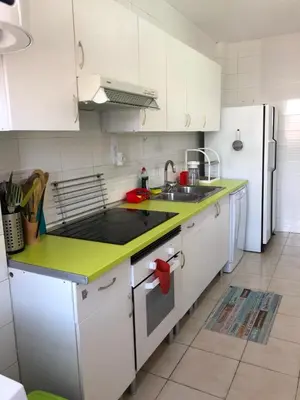 a kitchen with white cabinets and a green counter top at Apartamento Puerto de Sagunto Playa in Puerto de Sagunto