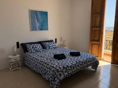 a bedroom with a bed with two black bags on it at Apartamento Puerto de Sagunto Playa in Puerto de Sagunto