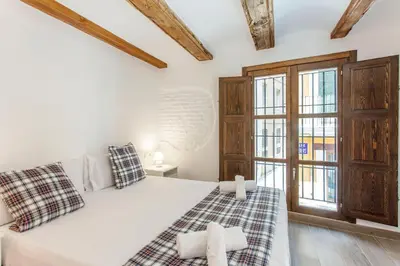 a bedroom with a white bed and windows at ApartUP Central Market II in Valencia