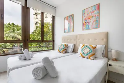 two beds in a bedroom with two windows at G&V APARTMENTS CLOSE to CENTER in Valencia