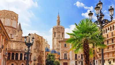 a cathedral with a palm tree in front of a building at G&V APARTMENTS CLOSE to CENTER in Valencia