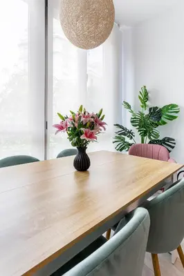 a dining room table with pink flowers in a vase at G&V APARTMENTS CLOSE to CENTER in Valencia